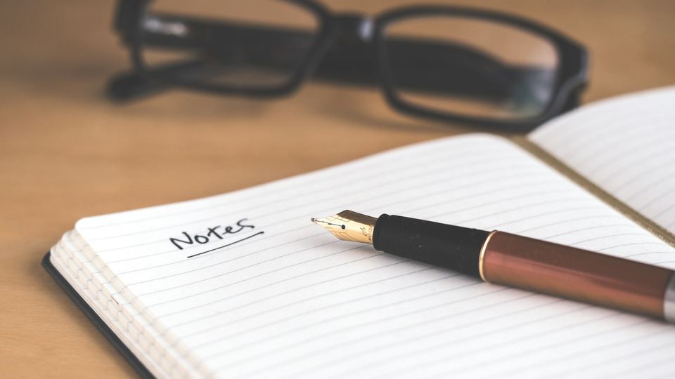 Stylo plume sur carnet ouvert — l'écriture artisanale, comme nos conseils digitaux : précis, sans jargon