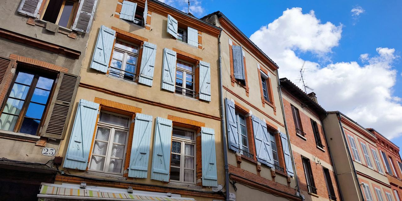 Toulouse, ville rose — rangée de façades en brique rose typique de l'architecture toulousaine sous le ciel d'Occitanie